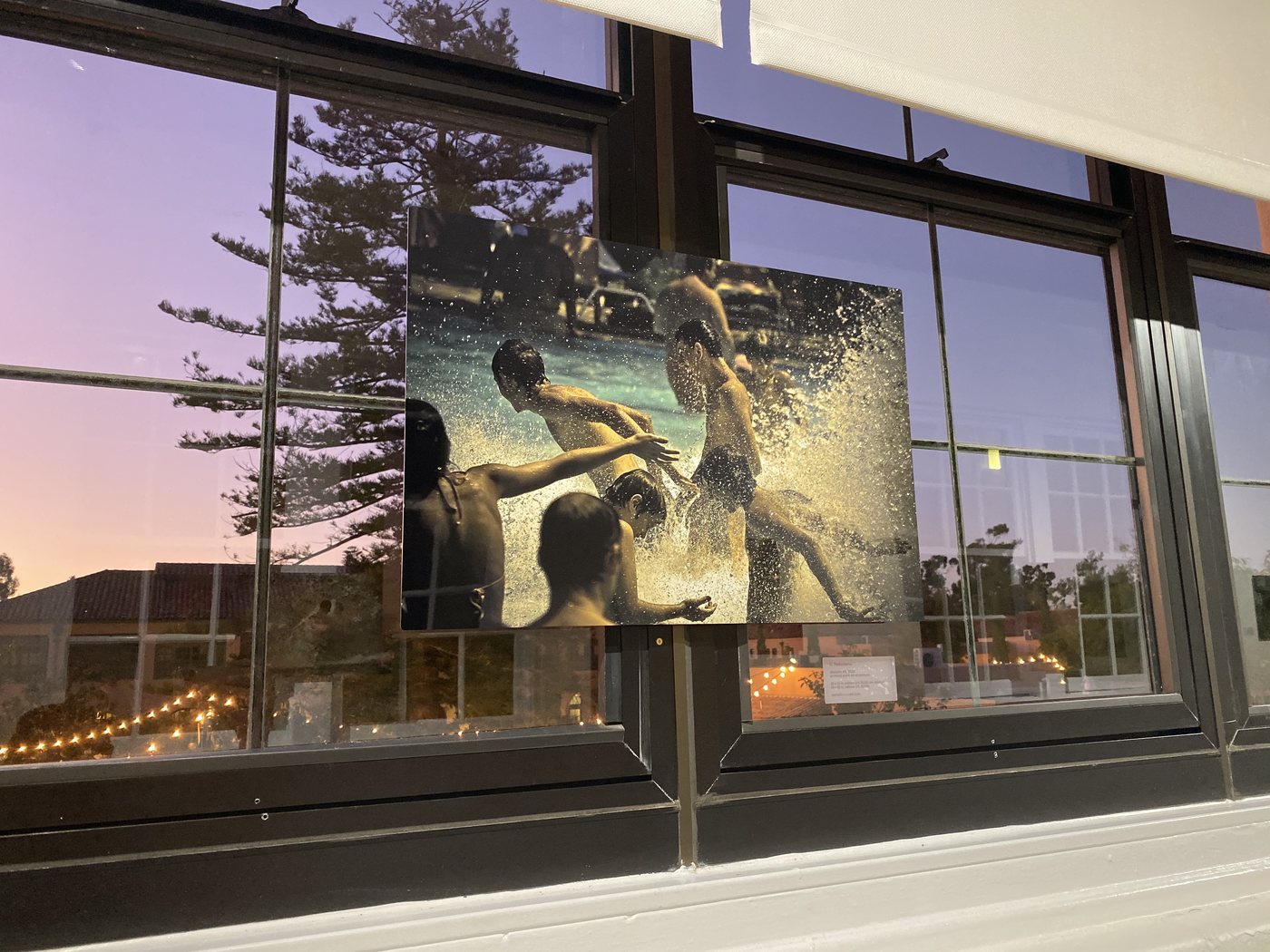 dancers, installation view at Cornel/Henry Art, San Diego, 2019 — a framed photograph on the wall, the gallery windows and dusk sky behind